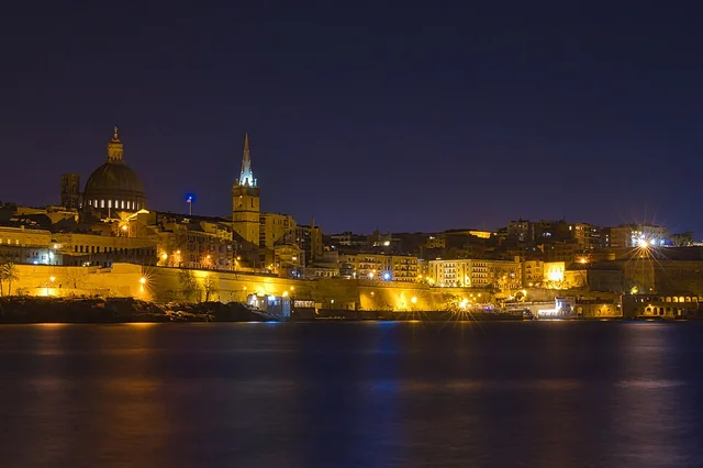 Deniz kıyısından Valletta'nın aydınlatılmış tarihî silüeti.